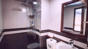 A modern bathroom with a toilet, sink, and shower. - Greenland Sa Pa Hotel by DLMH (Sa Pa)