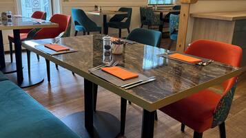 A dining area with a long table, multiple chairs, and a counter.