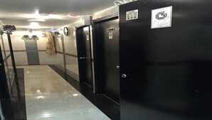 A corridor with black doors, each marked with a fire safety sign and a number. - Rich Hostel (Kowloon)