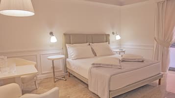 A neatly arranged bedroom with a bed, bedside tables, a small round table, and a chair.