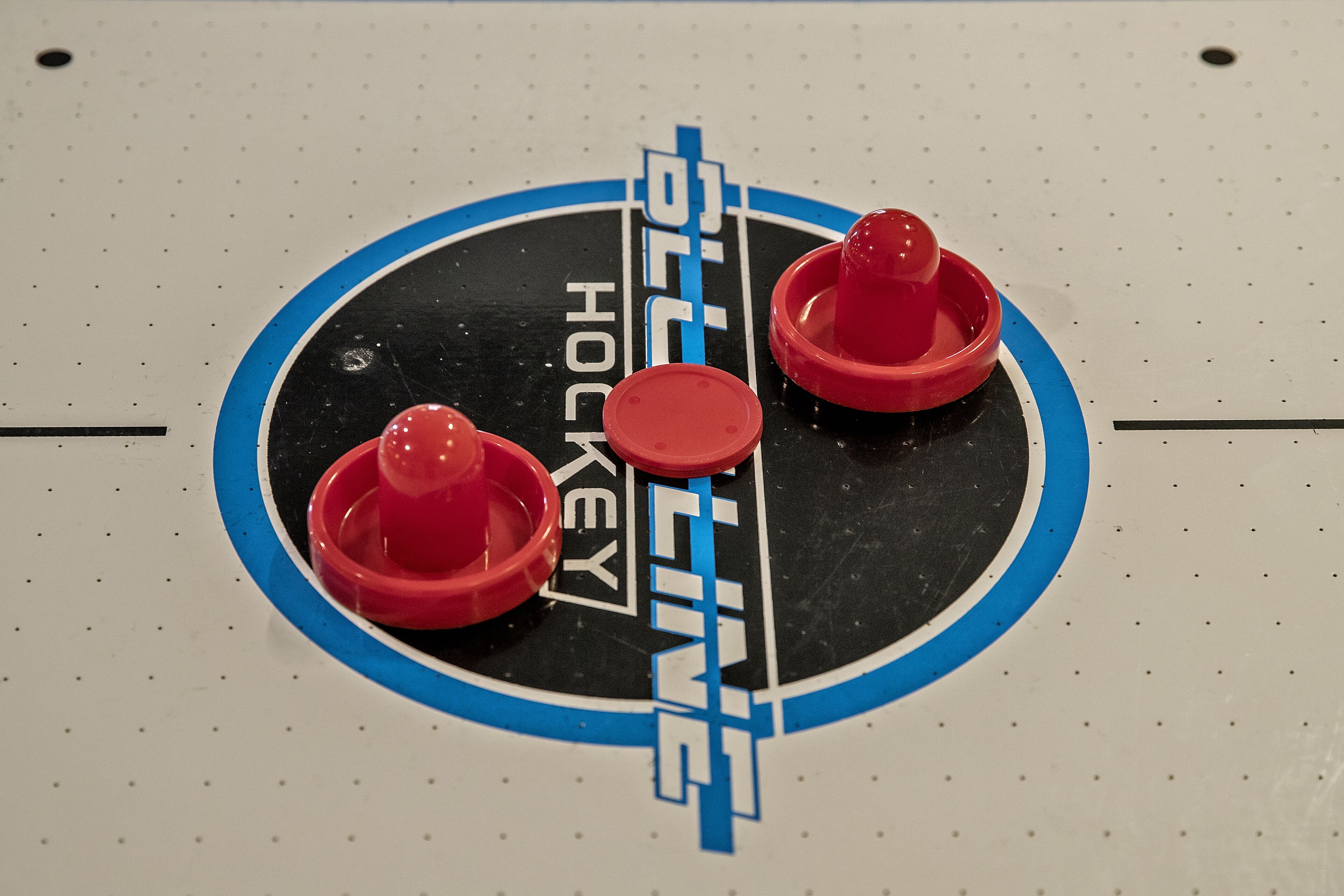 Eine Eishalle mit drei roten Pucken und den Schriftzügen 'Hockey' und 'BILLING'.