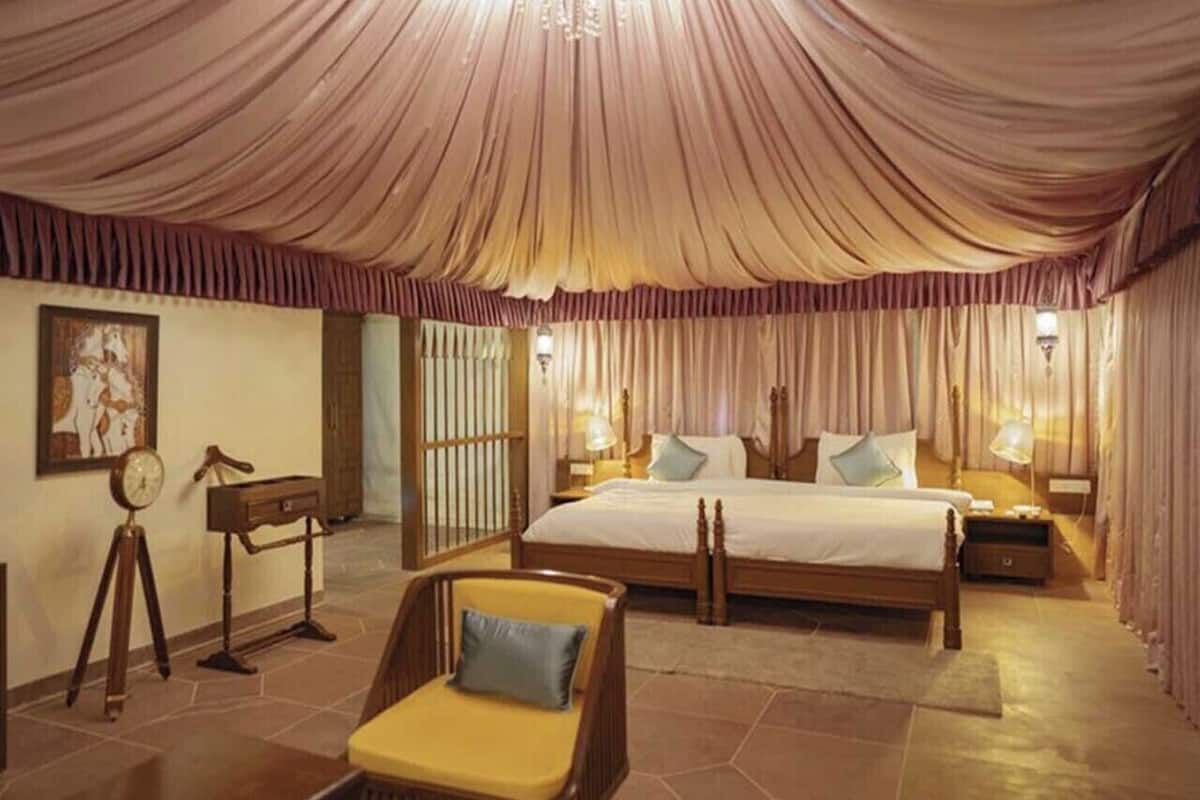 A spacious bedroom with a large bed, a chair, and a desk.