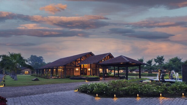 A resort with multiple buildings, a covered outdoor area, and a landscaped garden with pathways.