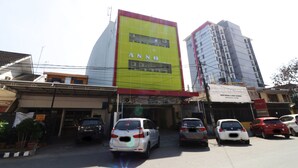 A building with a prominent yellow and red sign reading "ANNO" and a smaller sign below it. - Anno Guesthouse (Makassar)