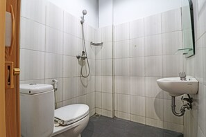 A bathroom with a toilet, a shower, and a sink.