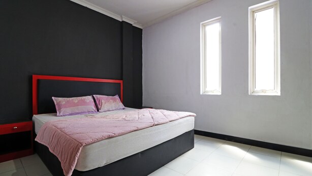 A bedroom with a bed, a nightstand, two windows, and a black and white wall color scheme. - Aurelia House A Mini Apartment (Pekanbaru)