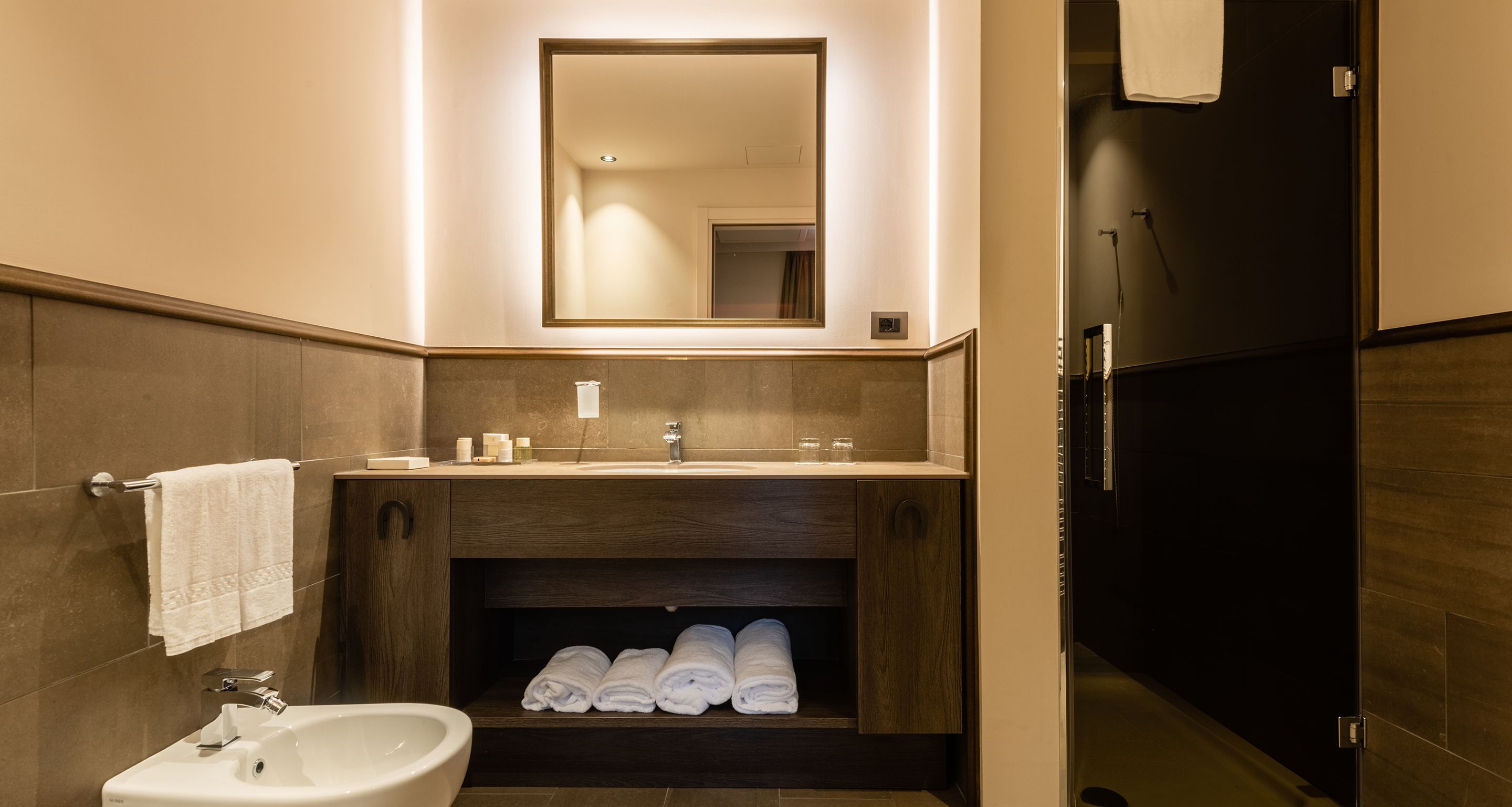 Une salle de bain moderne avec un lavabo, un miroir et un porte-serviettes.