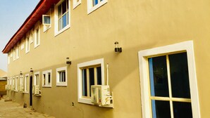 A building with multiple windows, some with air conditioning units attached.