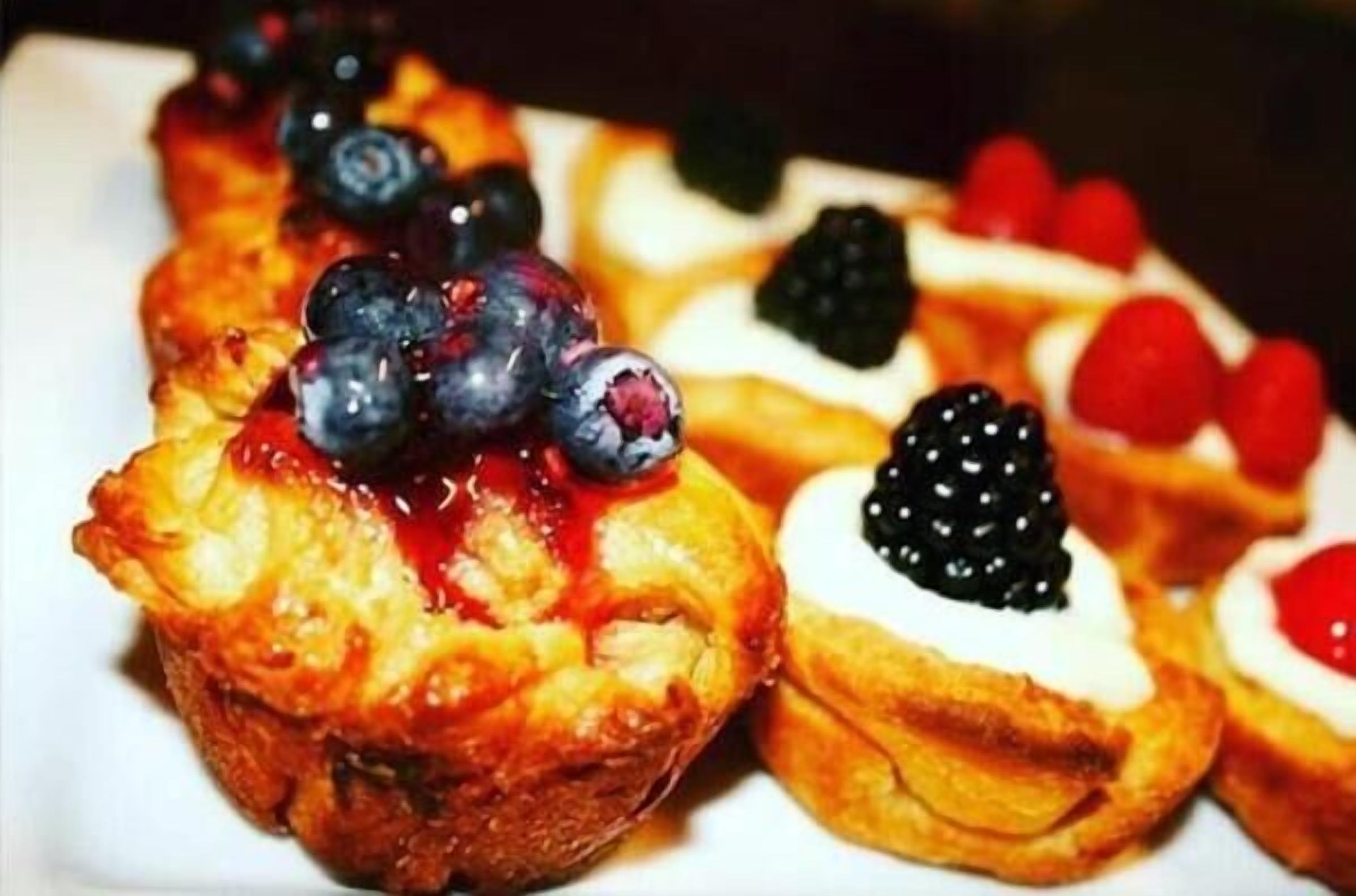 Verschiedene Backwaren mit Beeren und Sahne.