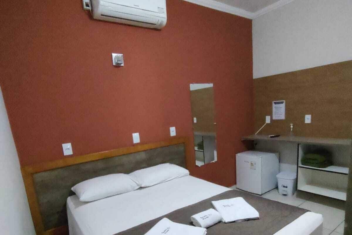 Ein Hotelzimmer mit einem Bett, einem Schreibtisch, einer Klimaanlage und einem Spiegel.