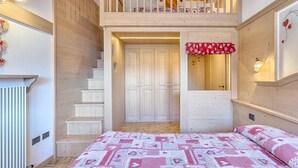 A bedroom with a bed, a staircase, and a balcony. - Residence Ronchi (Molveno)