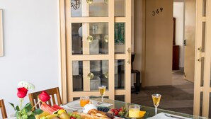 A dining table set with fruits, bread, and a glass of wine. - Air Lux (Mexico City)