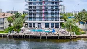 Una piscina al aire libre, sillones reclinables de piscina