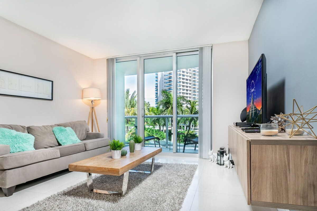 A modern living room with a sofa, a coffee table, and a TV.