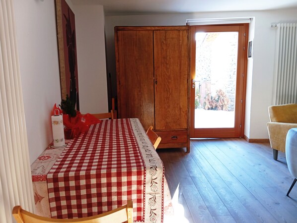 A dining area with a checkered tablecloth, wooden cabinet, and a view through a glass door. - Morge La Salle (La Salle)
