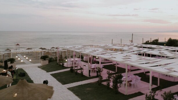 Terraza al aire libre con mesas y sillas, con vista al mar.