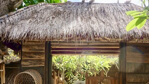 A rustic wooden structure with a thatched roof, a woven basket hanging on the wall, and a 'Welcome' sign on the door. - Pondok Kana Homestay (Penida Island)