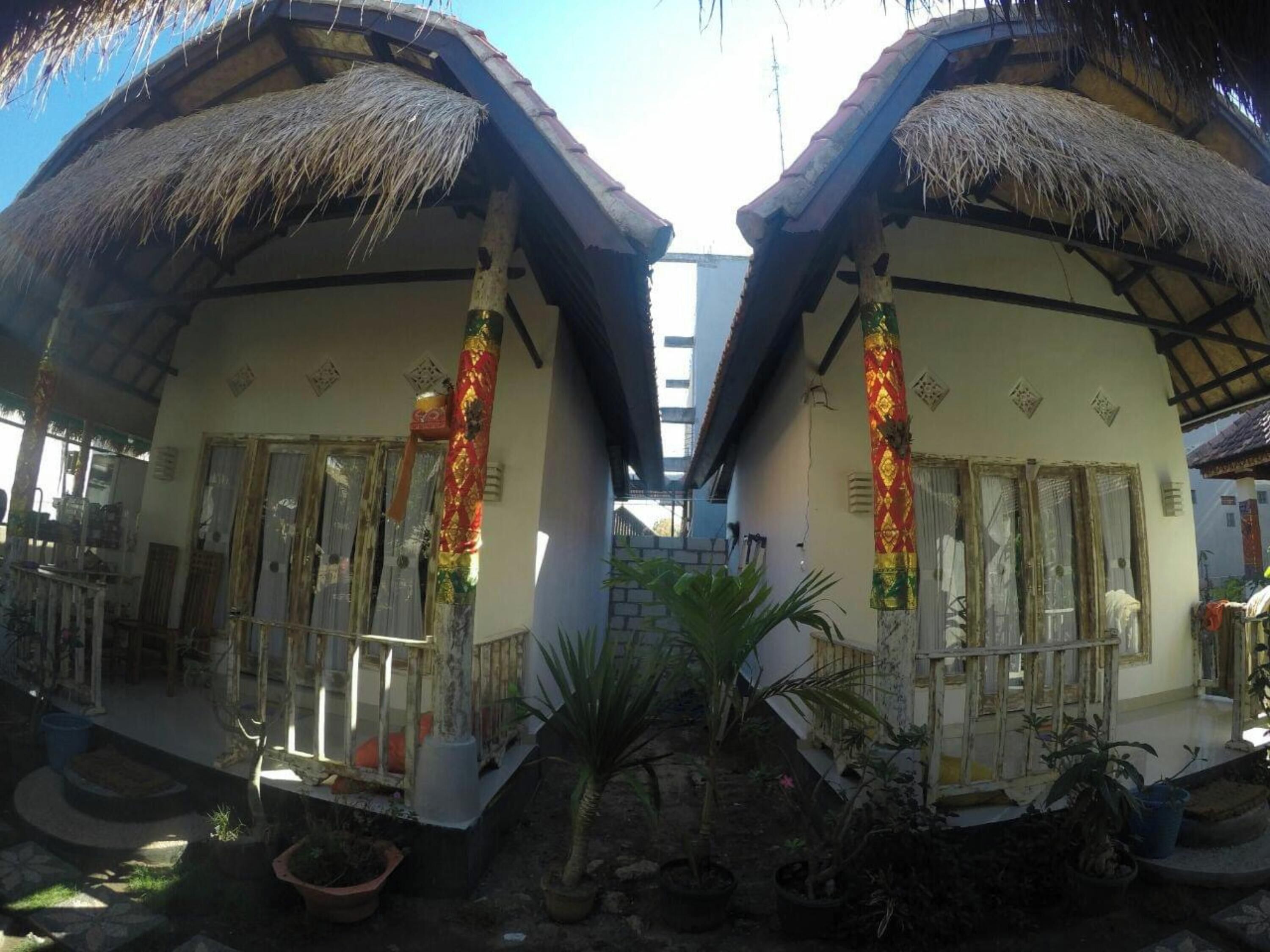 A traditional house with thatched roofs and a central staircase.