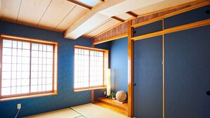 A traditional Japanese room with tatami flooring, shoji screens, and a sliding door. - Terrace House Tsubokawa (Naha)