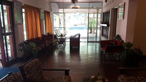Eine großzügige Lobby mit gemusterten Sofas, einem Couchtisch mit Blumen und Blick ins Freie durch große Fenster.
