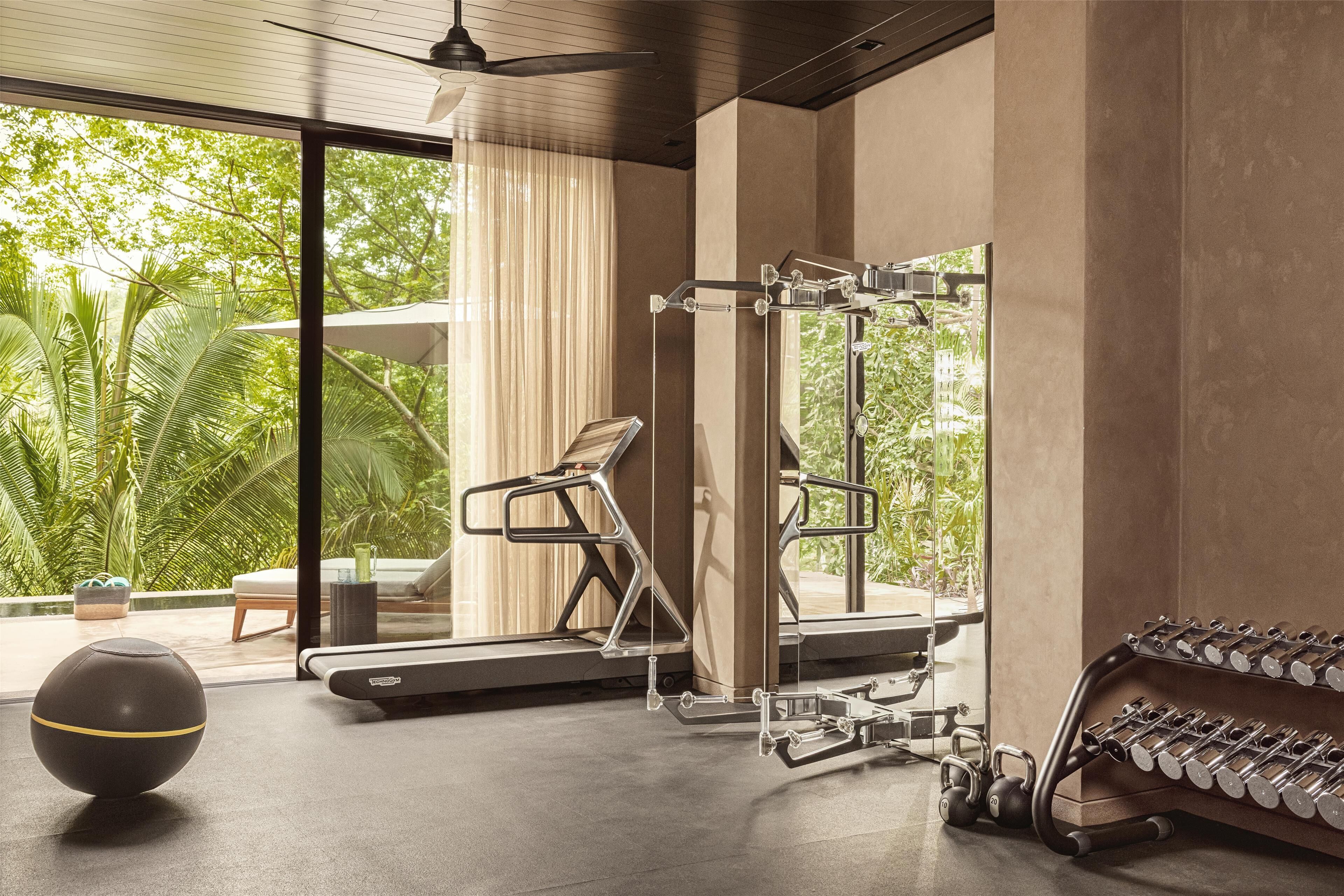 A modern gym with exercise equipment, a treadmill, and a weight rack.