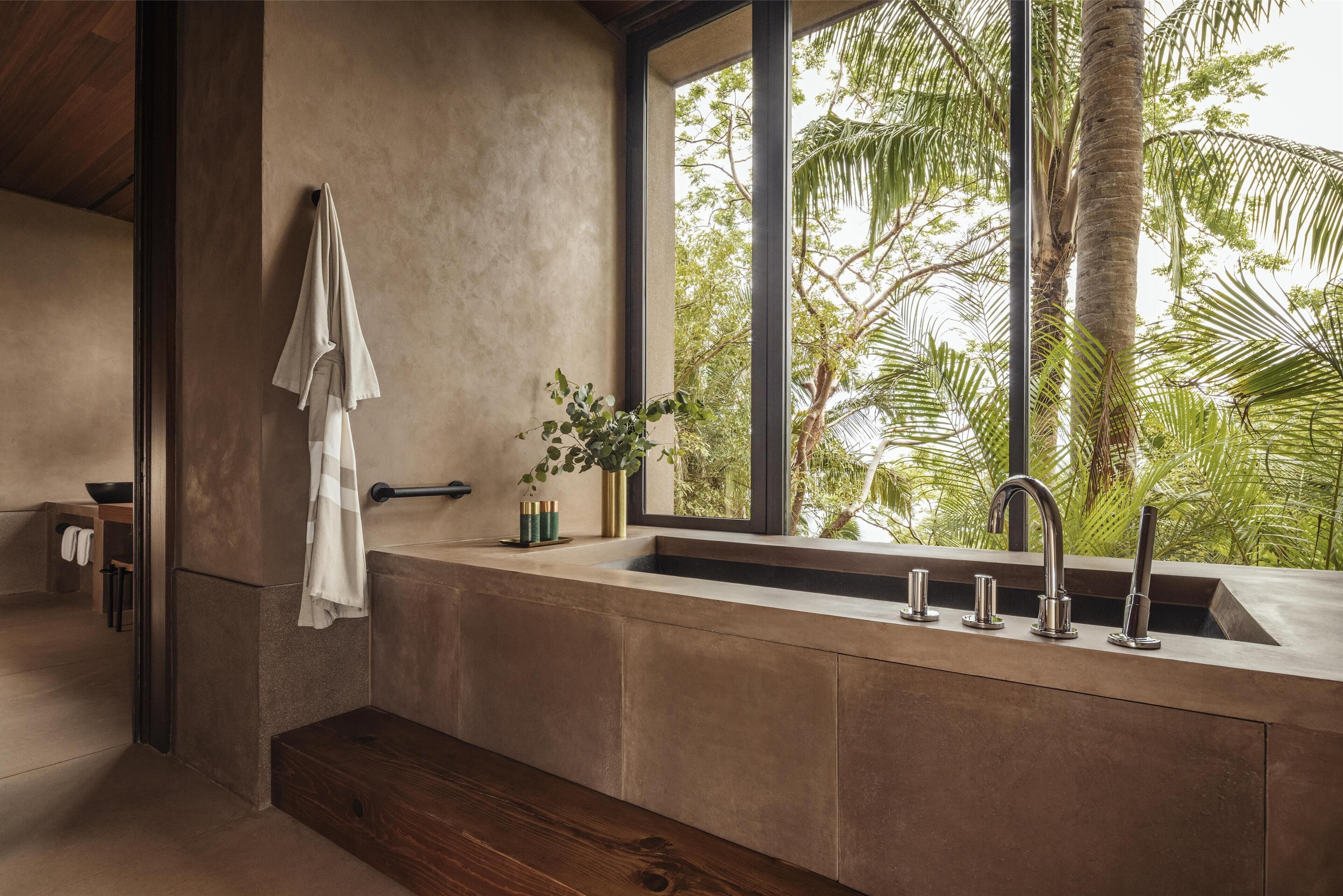 Une salle de bain moderne dotée d’une grande fenêtre, d’un lavabo encastré et d’un porte-serviettes.