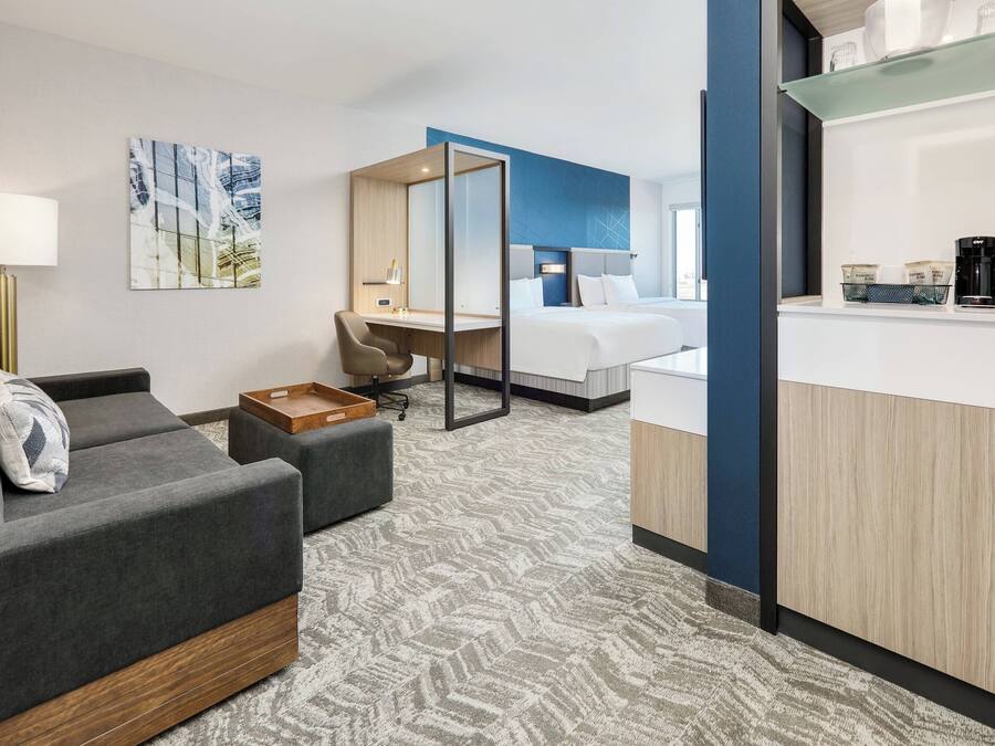 Une chambre d’hôtel équipée d’un canapé, d’un bureau, d’un lit et d’une machine à café.