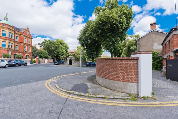 A street with a roundabout, brick wall, and red brick buildings. - The Edge Suite - hiphipstay (Dublin)