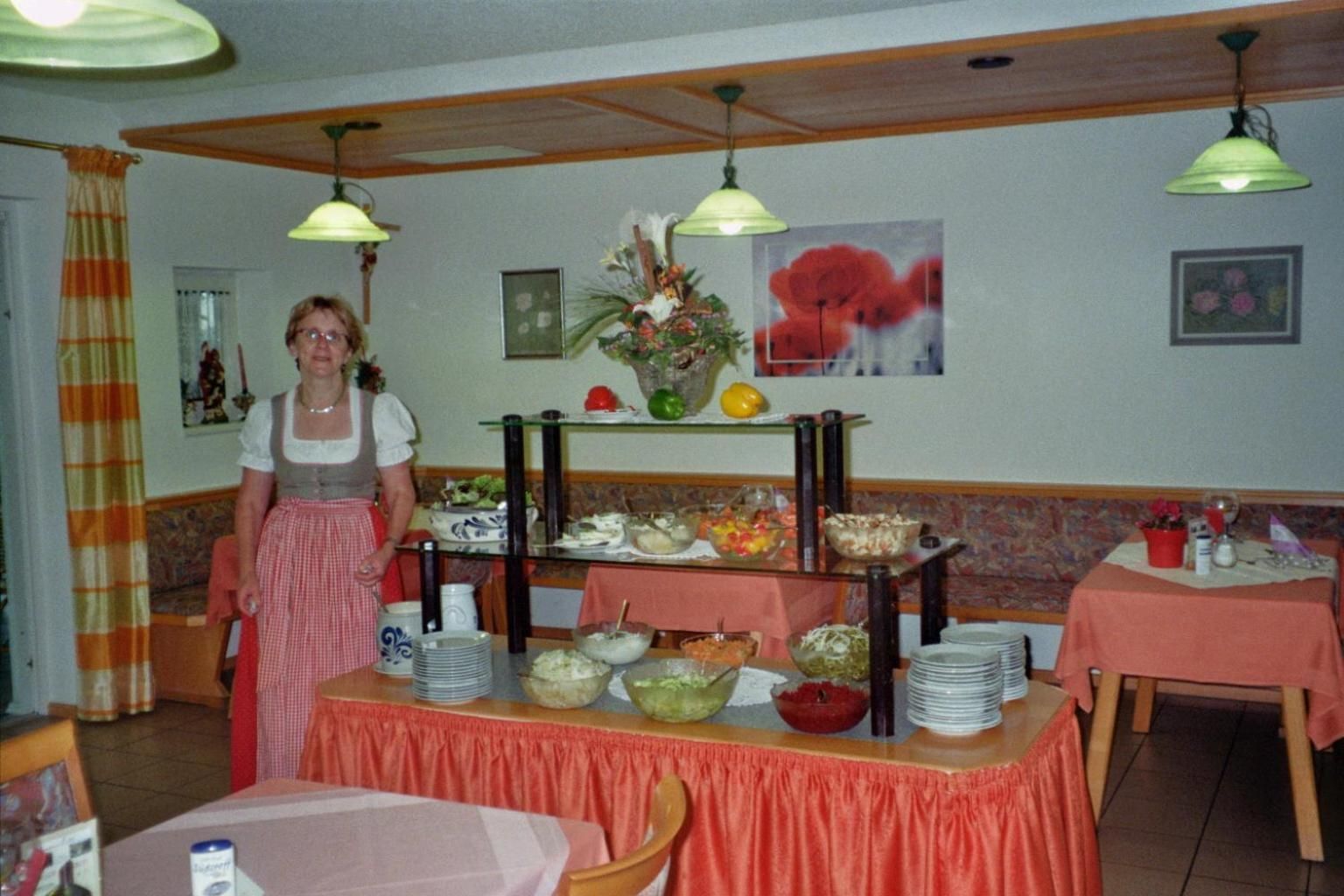 Un comedor con un sistema de buffet, una mesa con platos, tazones y diversas opciones de comida.