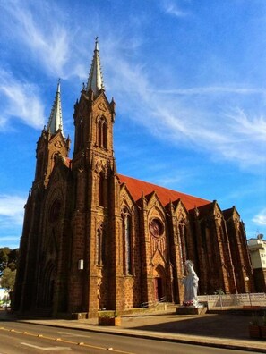 A large brick church with two spires and a red roof. - Hotel Pedra Moura (Vacaria)