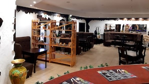 Um restaurante com interior rústico, com móveis de madeira e prateleiras com cerâmica.