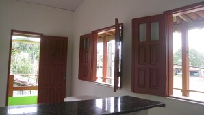Una cocina con encimera de granito, puertas de madera con paneles de vidrio y vistas al exterior.