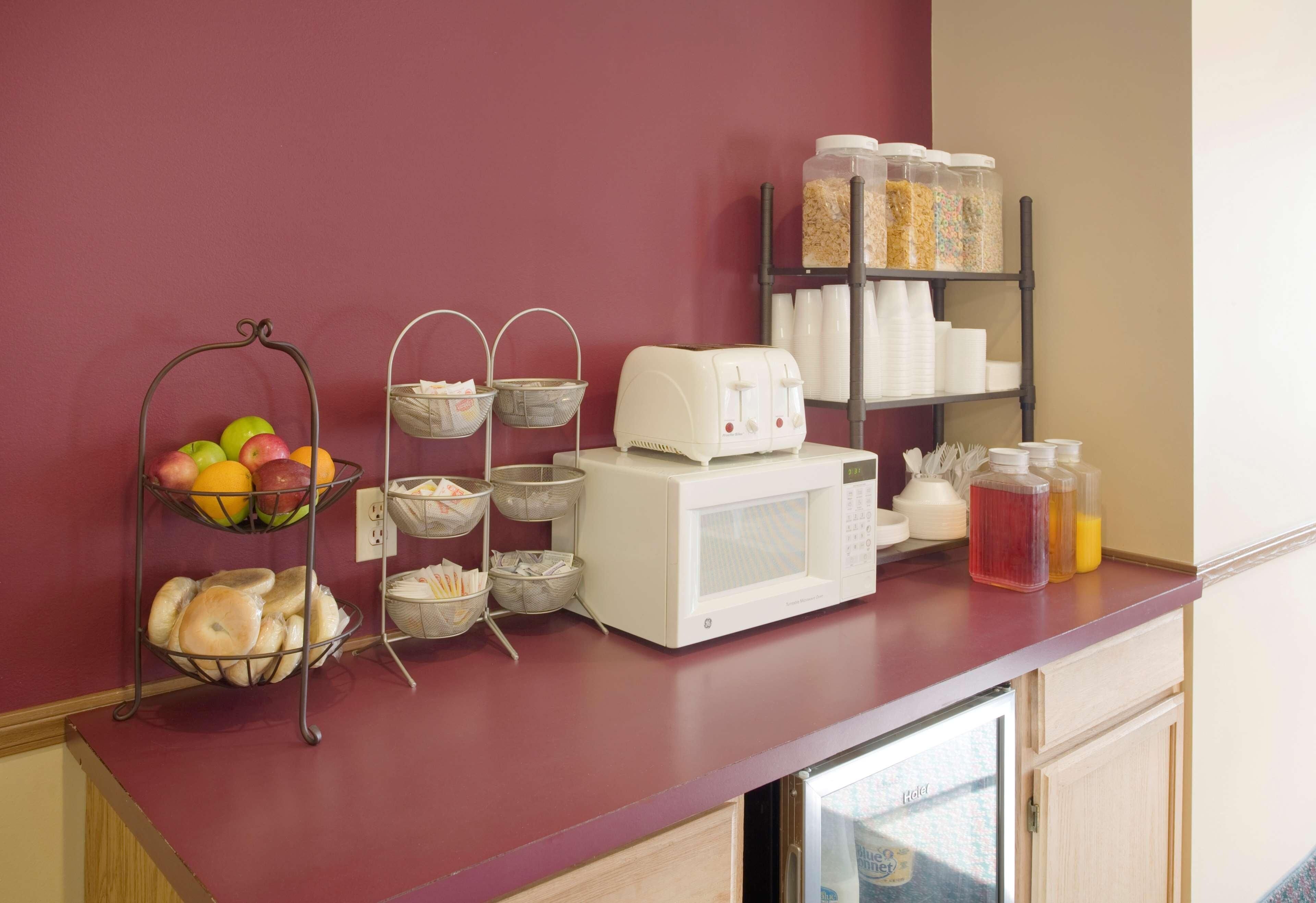 A kitchen counter with a fruit basket, a coffee maker, and storage containers.