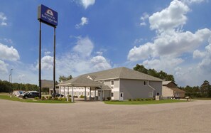 A Best Value Inn hotel with a large sign, a covered parking area, and a well-maintained lawn. - Americas Best Value Inn Gaylord (Gaylord)