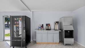 A modern kitchen with a built-in coffee machine, a refrigerator, and a freezer.