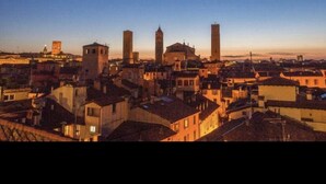 Un paisaje urbano con varios edificios, incluyendo una torre destacada y otras estructuras más pequeñas.