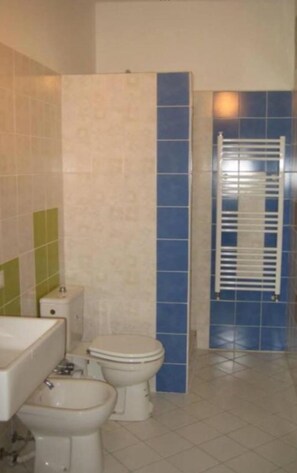 A bathroom with two toilets, a sink, and a towel rack. - Verdi Plaza - Hostel (Bologna)