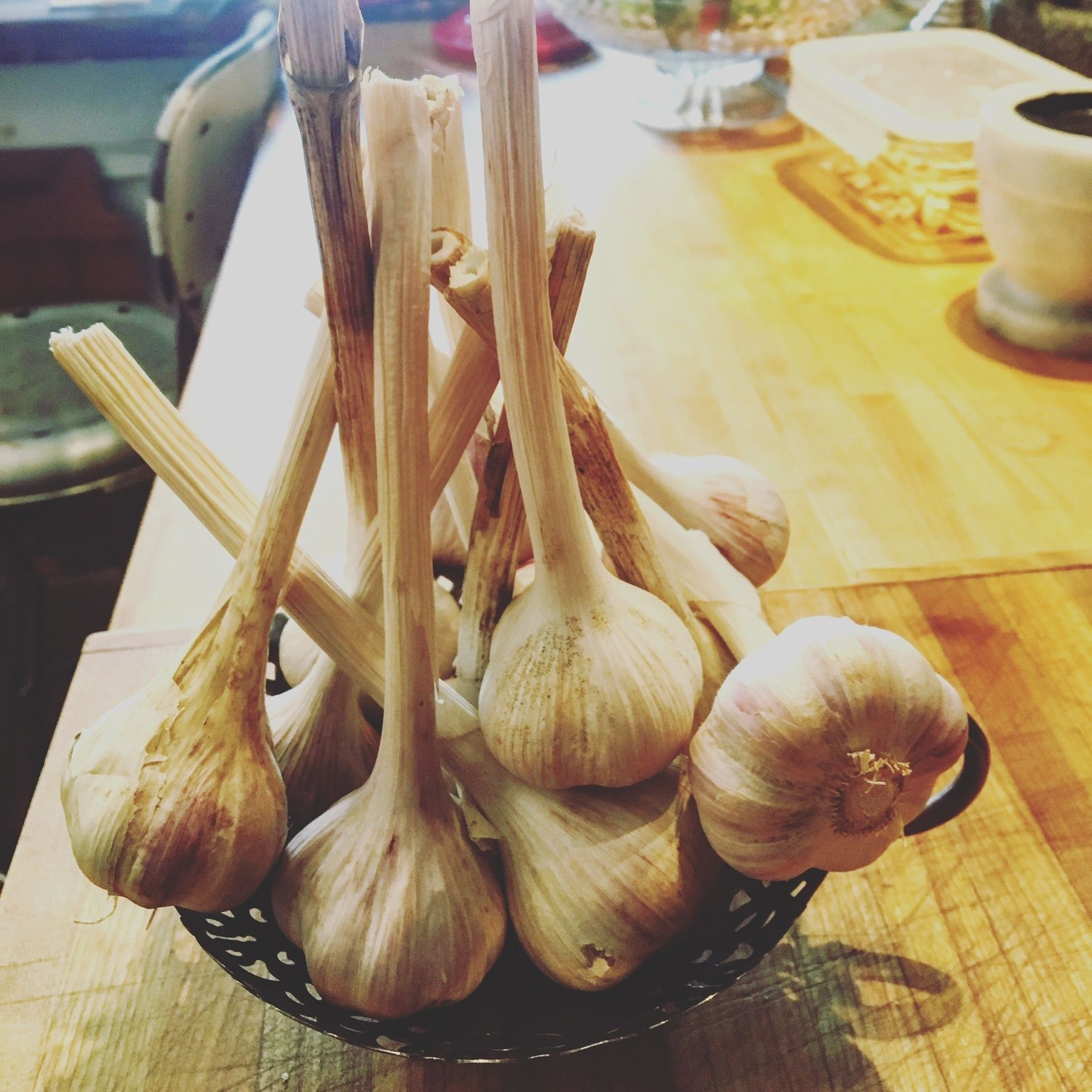 A bowl of garlic cloves on a wooden table.
