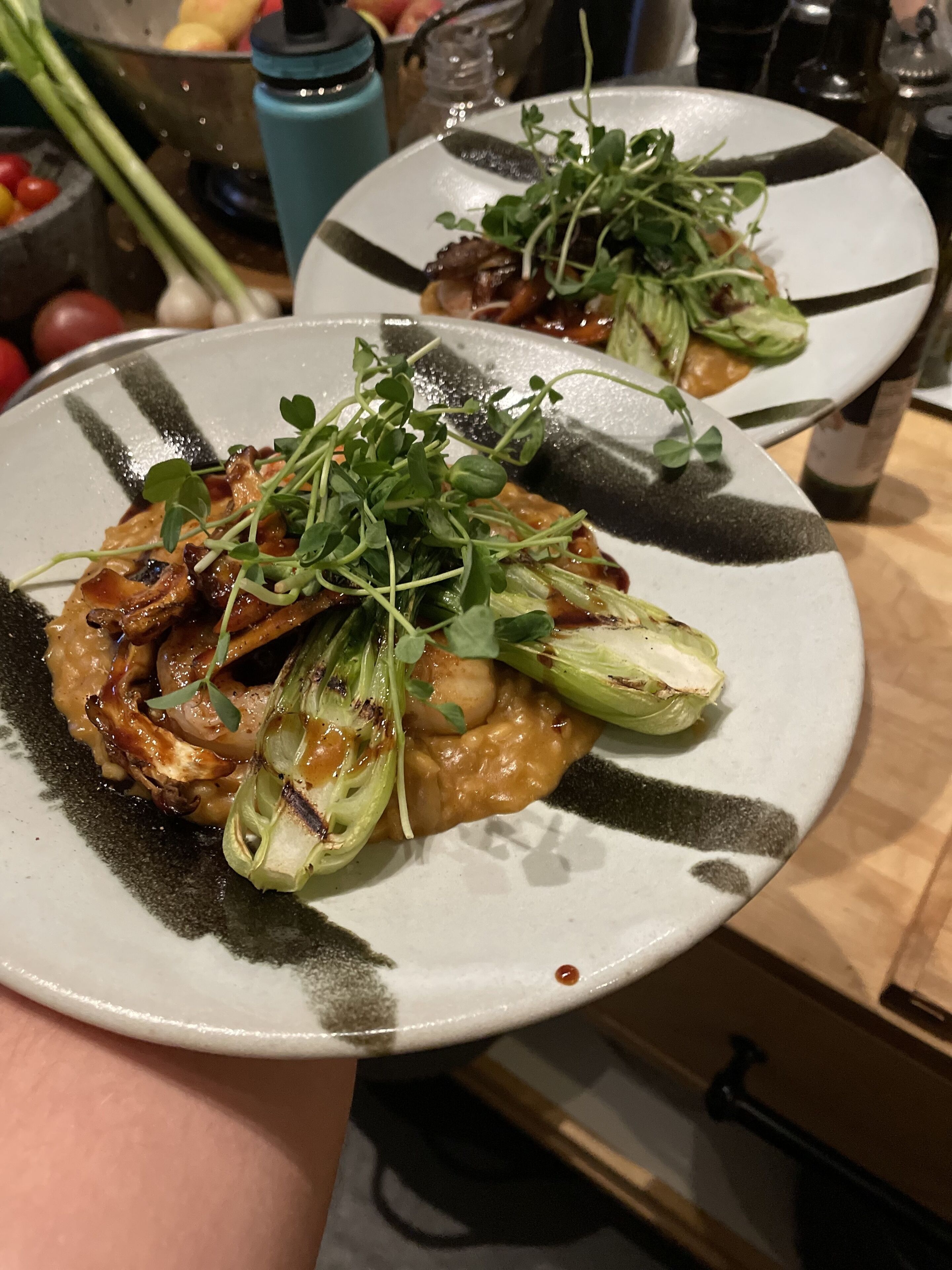 Une assiette de nourriture contenant des légumes verts et des champignons, tenue par une personne.
