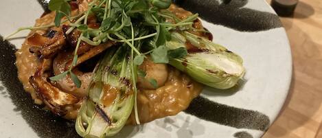 Een bord eten met groenten en champignons, vastgehouden door een persoon.