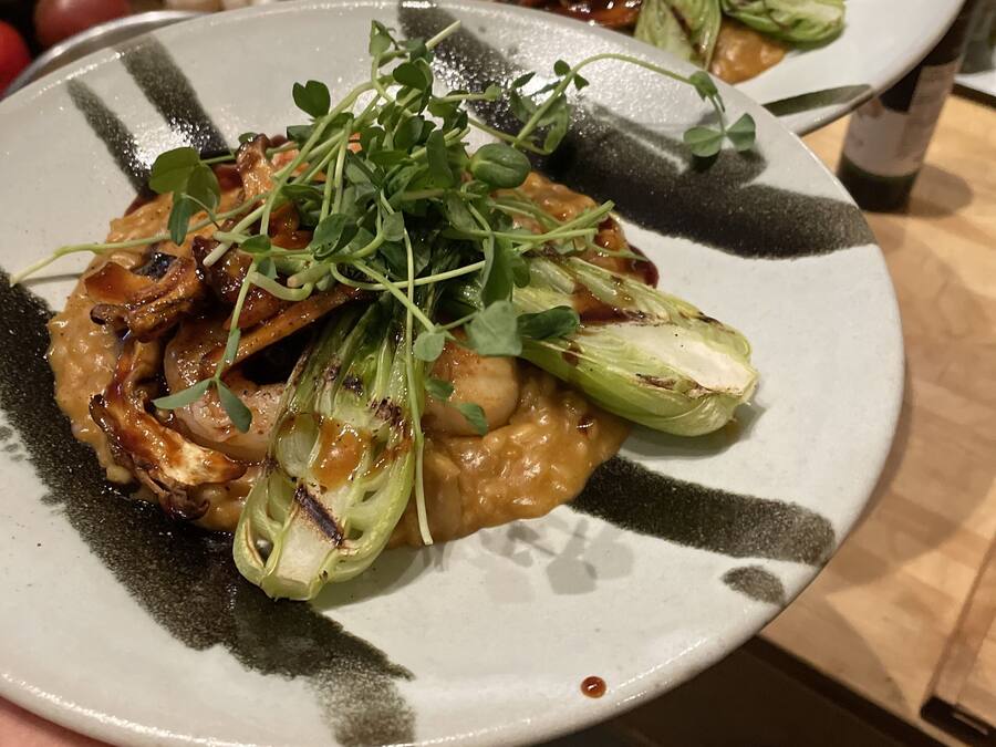 Une assiette de nourriture contenant des légumes verts et des champignons, tenue par une personne.