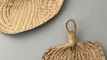 Two woven, circular objects with handles, likely serving as decorative items or small furniture pieces.