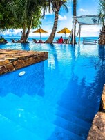 En la playa, arena blanca, sillas reclinables de playa, sombrillas