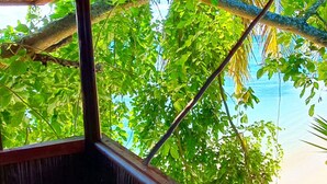Una estructura de madera con vista a una playa y palmeras.