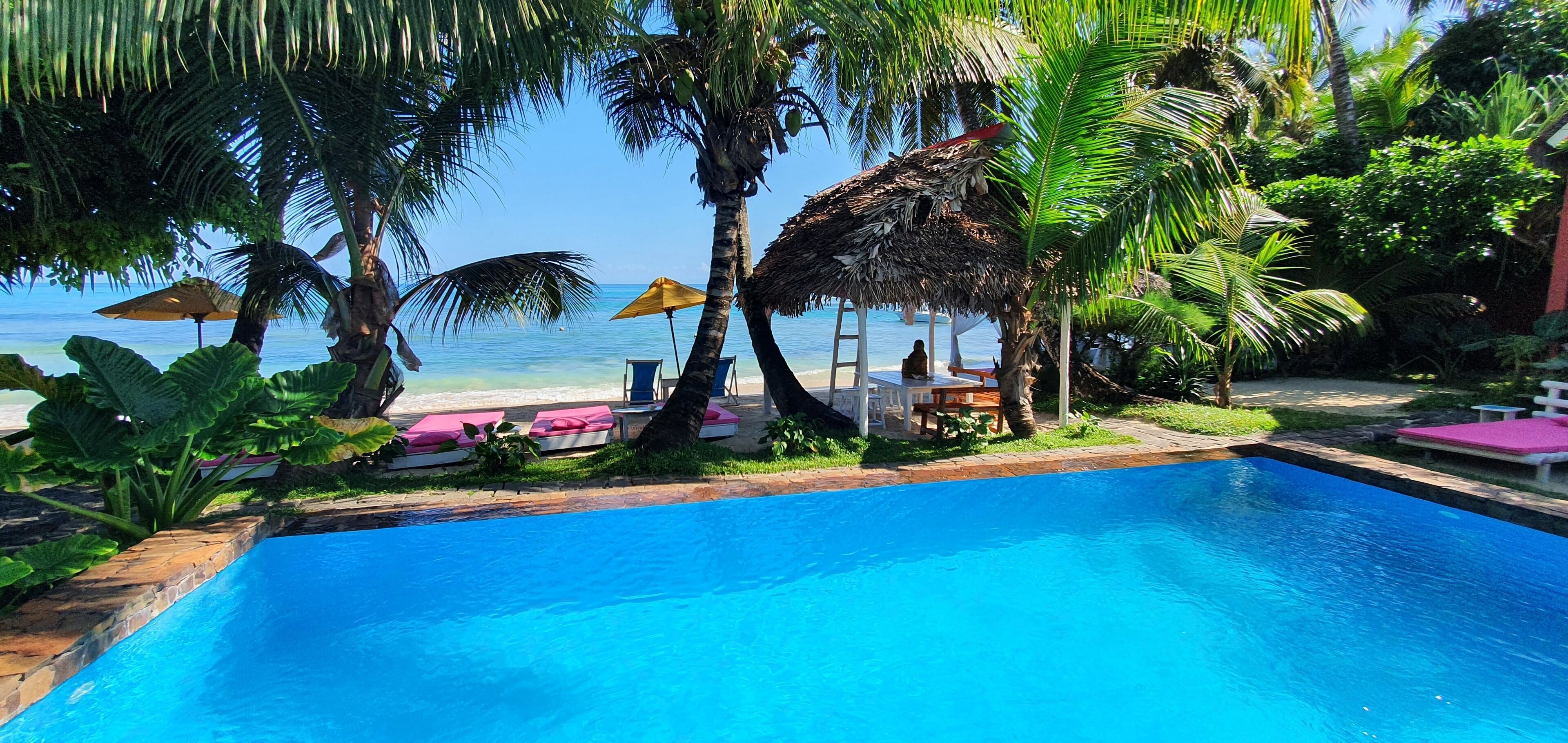Am Strand, weißer Sandstrand, Liegestühle, Sonnenschirme