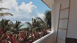 Un balcón con vista al océano y palmeras.
