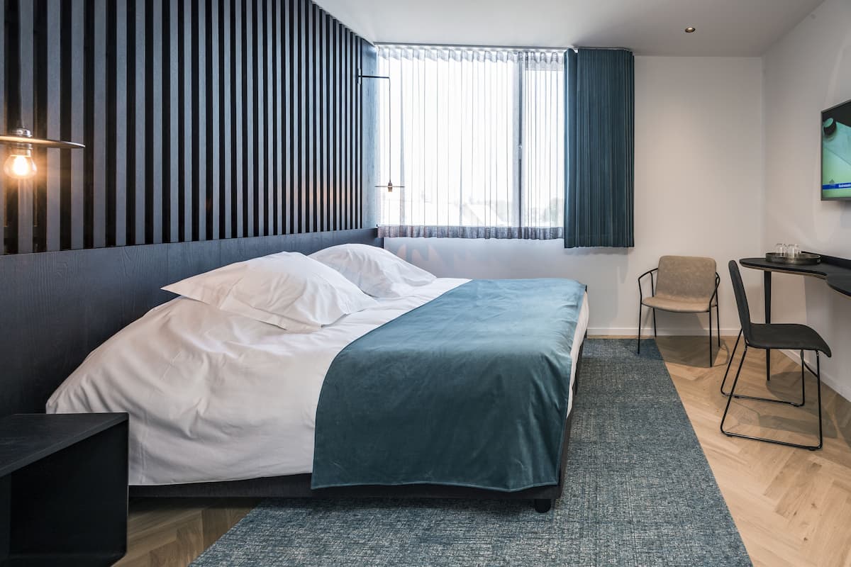 Deluxe tweepersoonskamer | Donzen dekbedden, een minibar, een kluis op de kamer, een bureau
