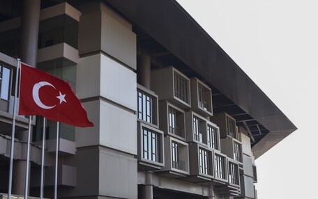 A modern building with a flagpole displaying a flag.
