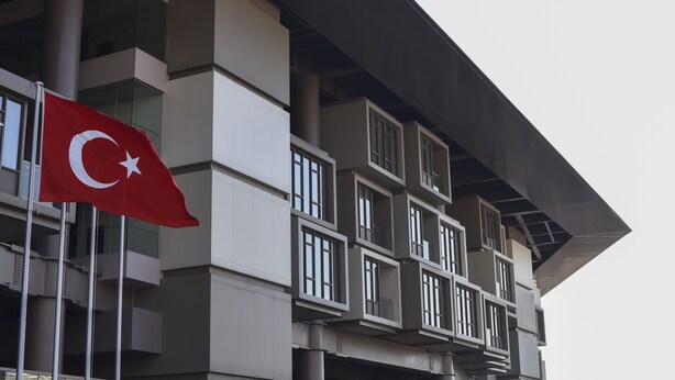 Un edificio moderno con un asta mostrando una bandera.