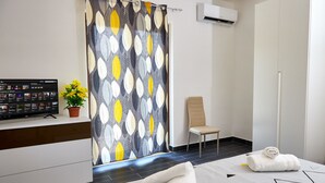 A hotel room with a bed, a chair, a TV, and a potted plant. - Cilentia B&B (Agropoli)